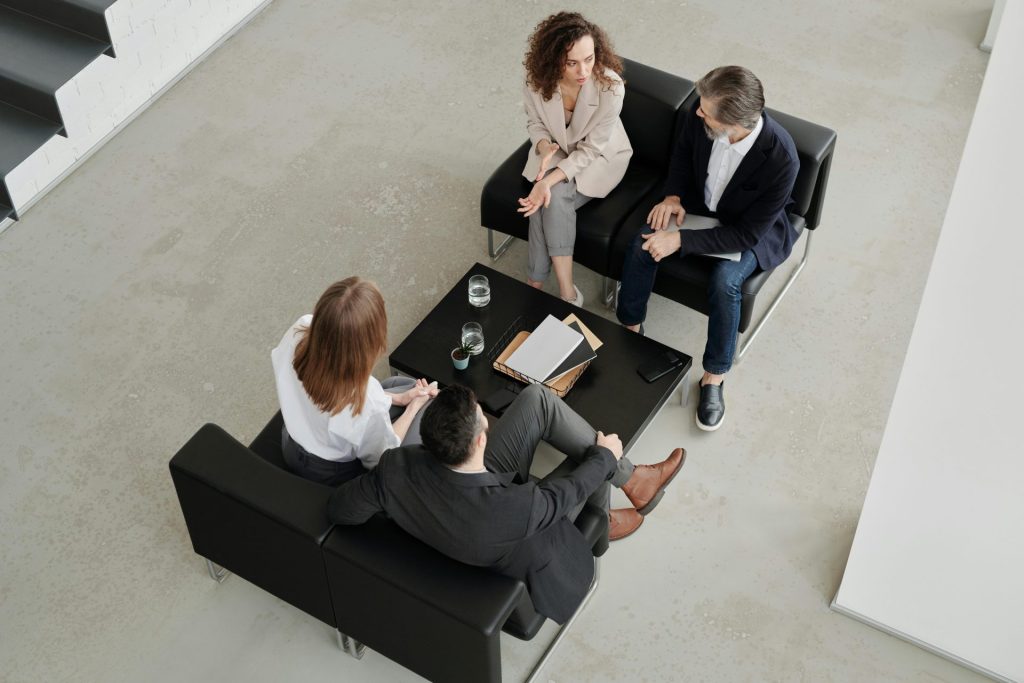 A group of professionals engaged in a collaborative business meeting in a modern office setting.