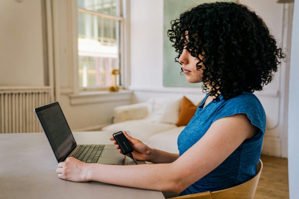 A woman sitting at a table using a laptop computer